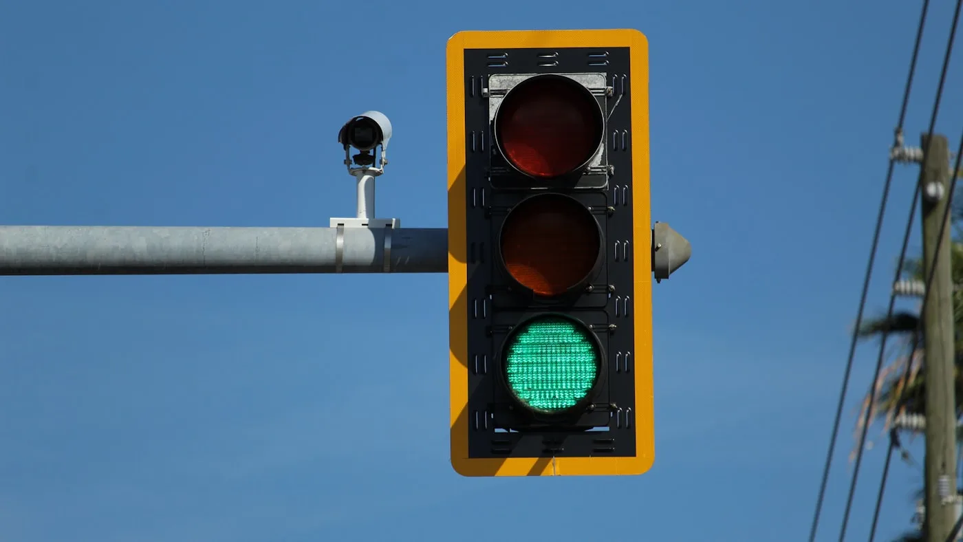 A traffic light showing green against a clear blue sky