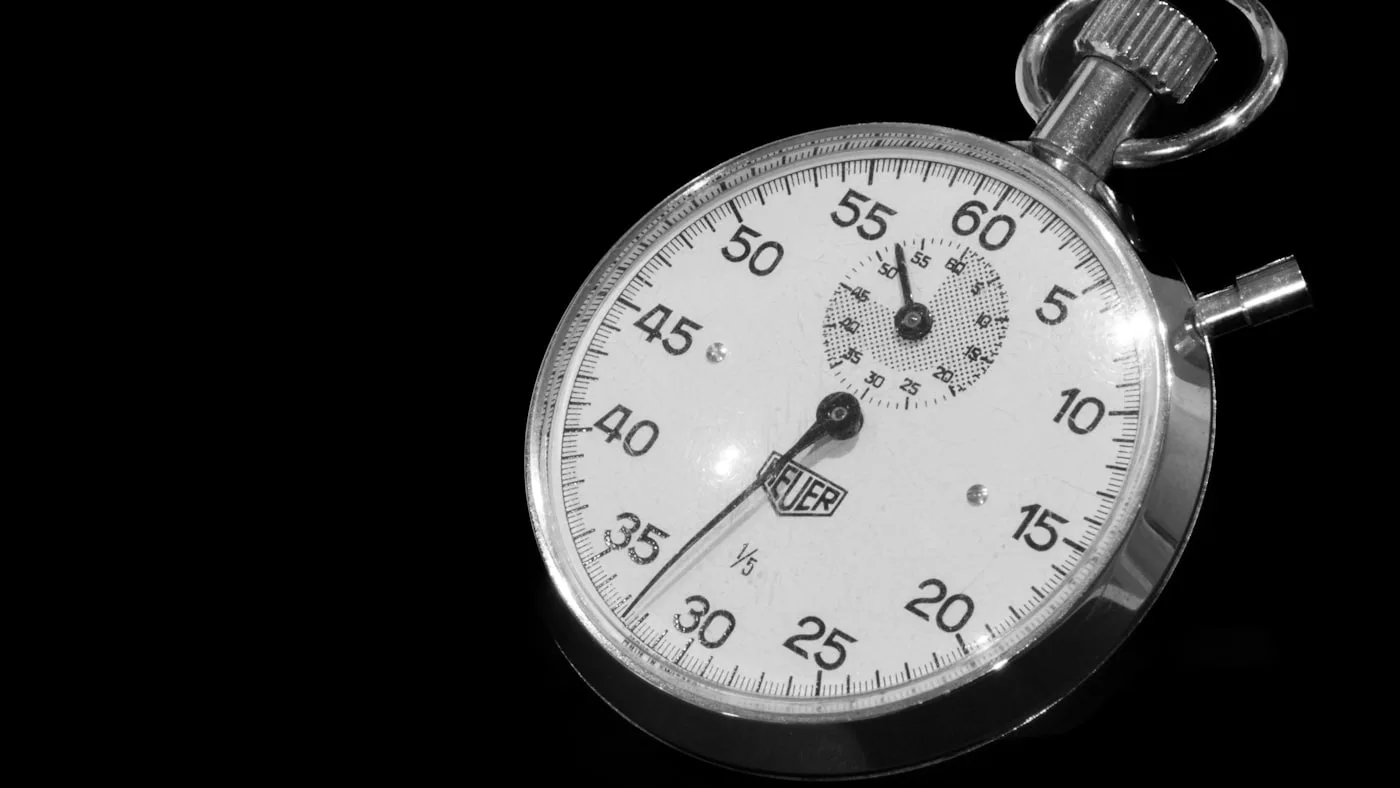 A silver stopwatch on a black background